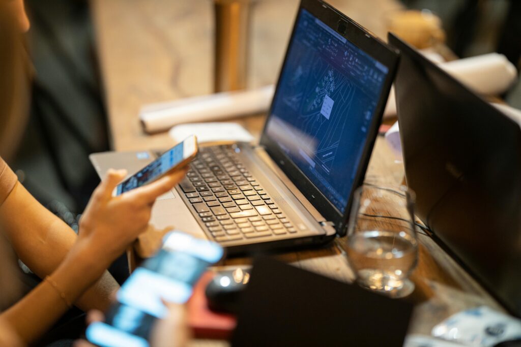 A close-up of a modern workspace, featuring a laptop and smartphone in use.